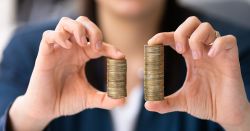 woman holding two stacks of coins between her fingers